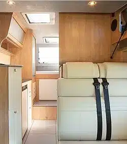 Innenraum des la strada NOVA M mit Sitzgruppe, Küche und Holzverkleidung