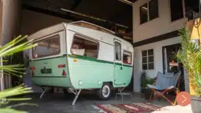 Restaurierter grün-weißer Otten Kruiser Caravan in einer überdachten Umgebung