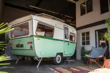 Restaurierter grün-weißer Otten Kruiser Caravan in einer überdachten Umgebung