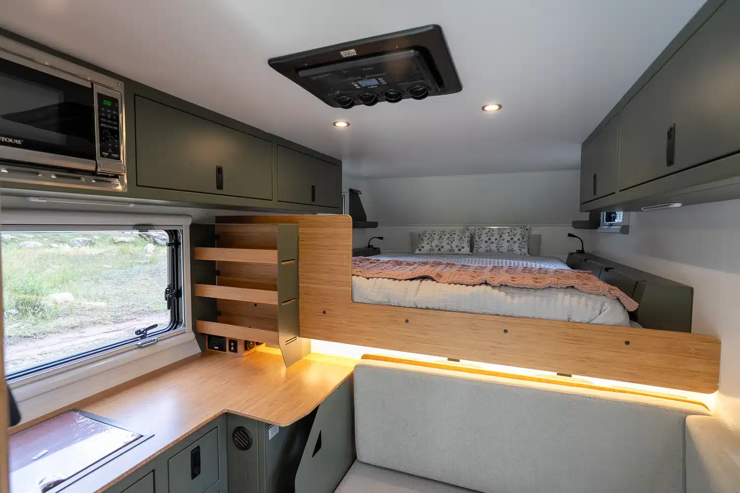 Innenansicht der Outpost 8.0 Wohnkabine mit Bett, Sitzgruppe, Schränken und Dachlüfter