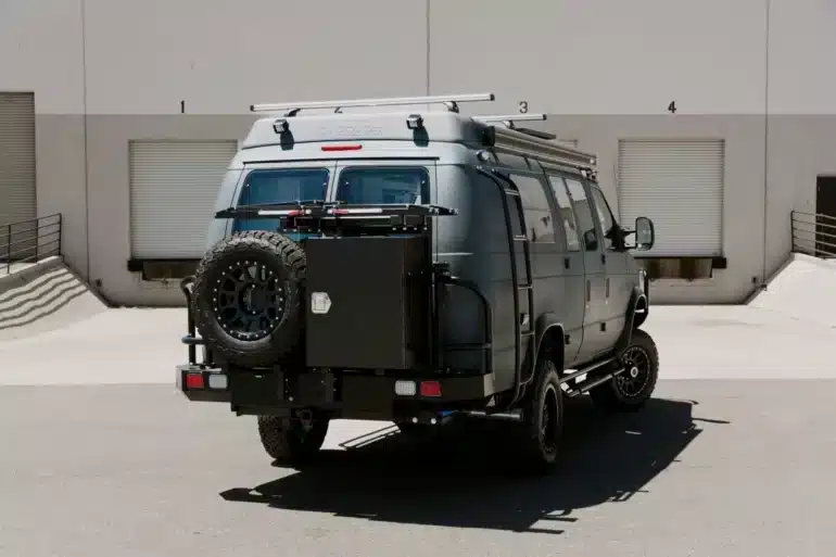 Field Van Peak 4x4-Camper in grauer Ausführung mit Ersatzrad und Offroad-Ausstattung von hinten
