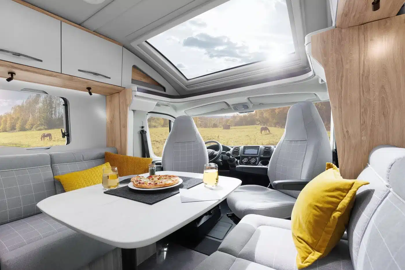 Innenraum des Eura Mobil Profila T mit Sitzgruppe, Fahrerhaus, Tisch und Holzdekor