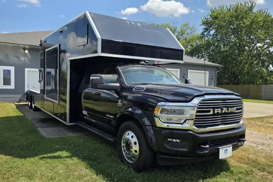 Schwarzer 2024 Ram 5500 Laramie Custom Car Hauler mit großem Wohnaufbau vor einem Wohnhaus
