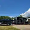 Schwarzer Ram 5500 Laramie Custom Car Hauler mit Wohnaufbau und schwarzem Fahrzeug auf der Laderampe