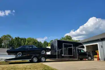 Schwarzer Ram 5500 Laramie Custom Car Hauler mit Wohnaufbau und schwarzem Fahrzeug auf der Laderampe