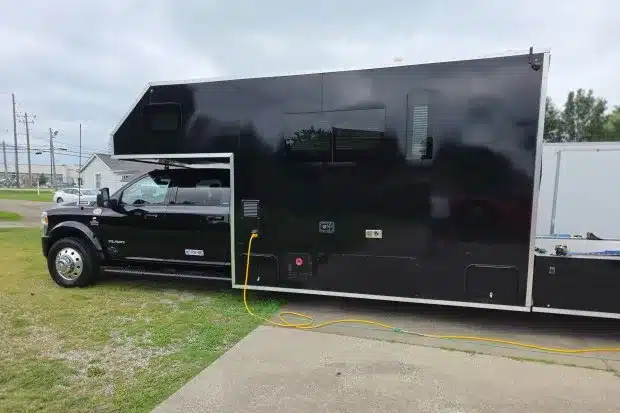 Schwarzer 2024 Ram 5500 Laramie Custom Car Hauler mit großem Wohnaufbau auf einem Außengelände