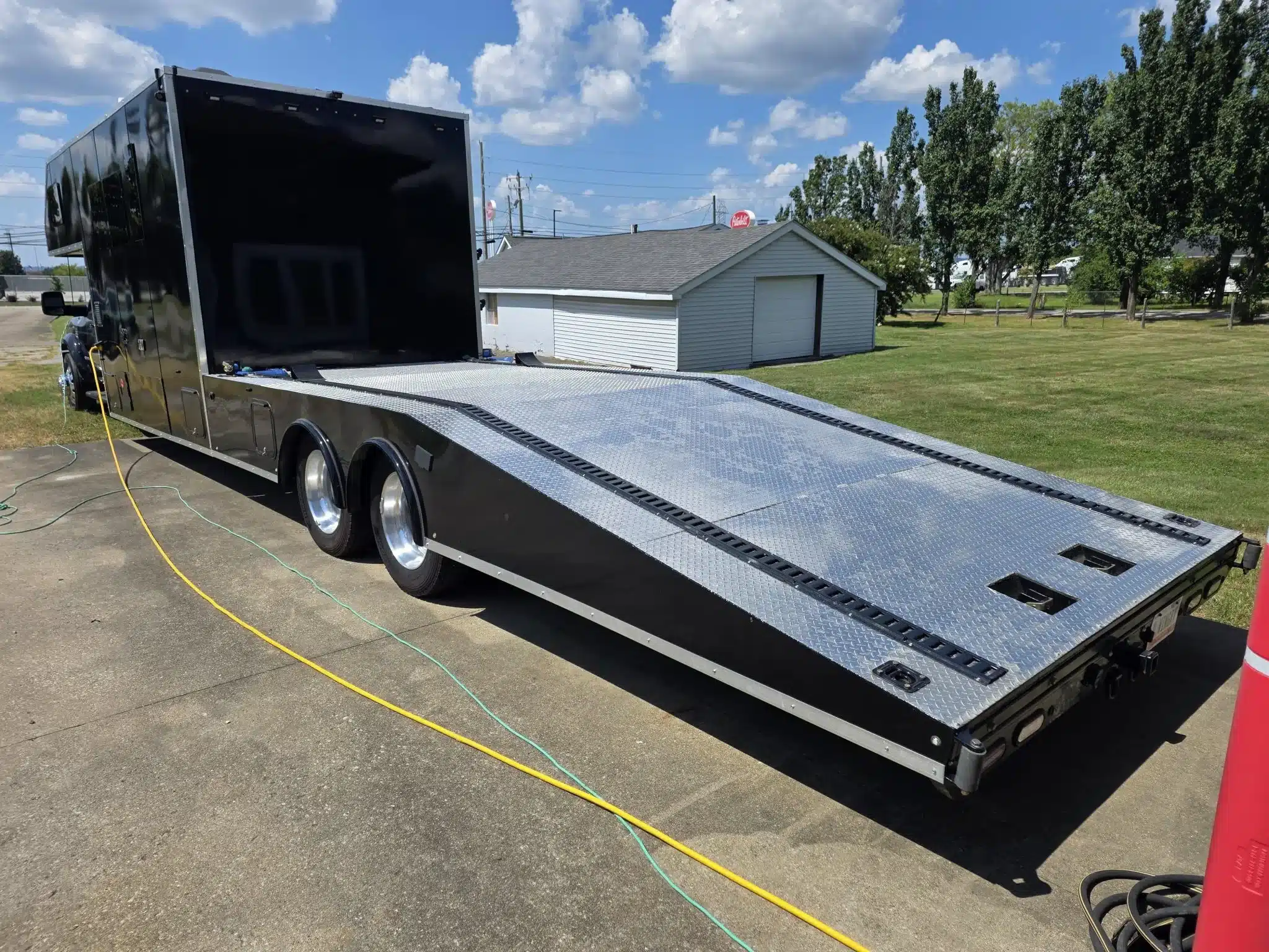 Heckansicht eines schwarzen Ram 5500 Custom Car Haulers mit langer Aluminium-Ladefläche und Rampen