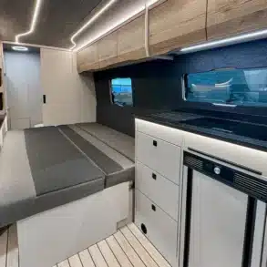 Innenraum des Rhön Camp The Seeker mit ausgezogenem Loungesofa, Küchenzeile und Oberschränken