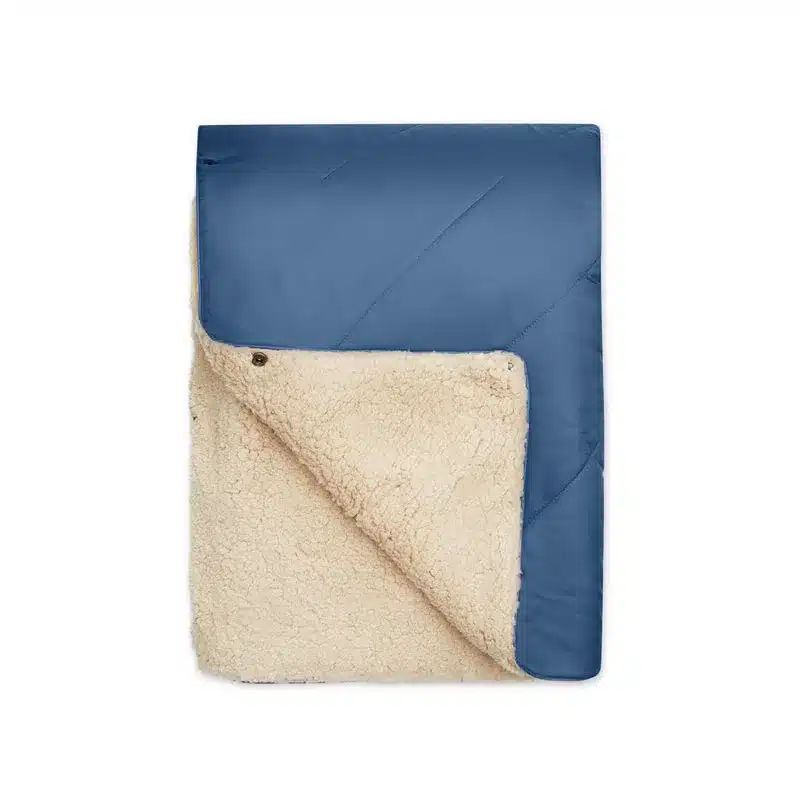 Blaue UNFOLD Kuscheldecke mit aufgeklappter weicher Sherpa-Fleece-Innenseite