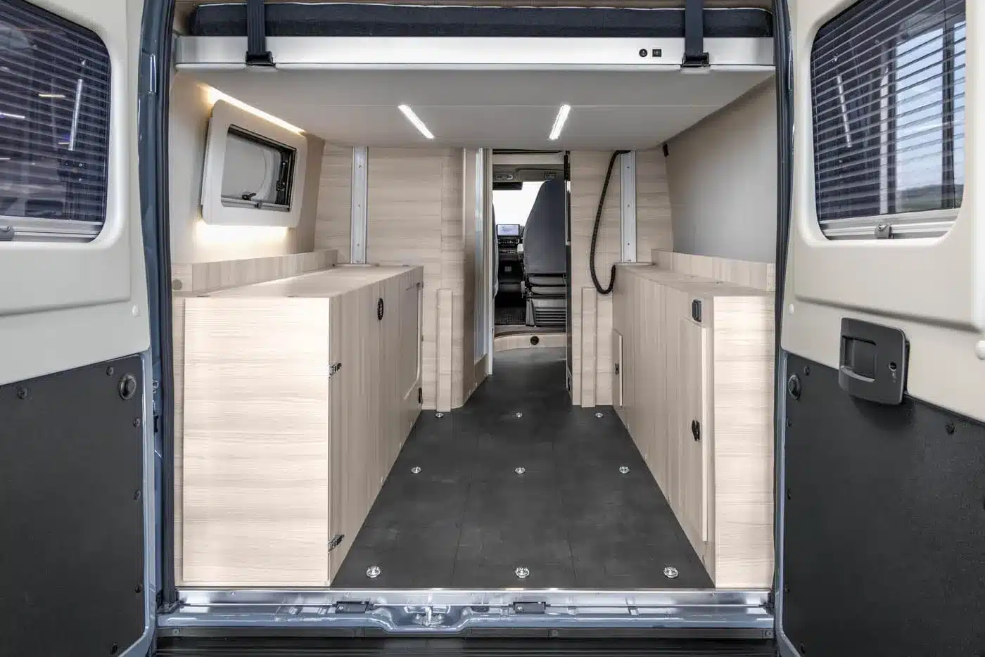 Innenansicht eines Vancona Campervans mit Holzoptik-Möbeln, Stauraum und variabler Ladefläche