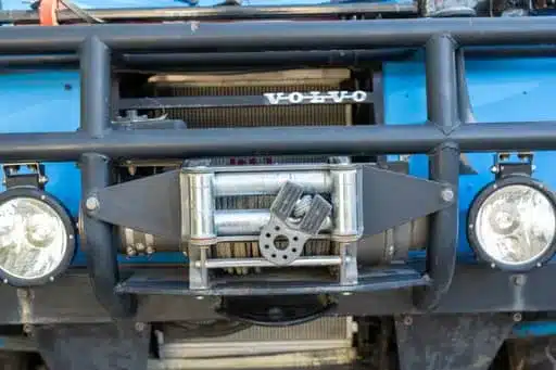 Frontdetail eines blauen Volvo C303 TGB 1111 mit schwarzem Schutzgitter und montierter Seilwinde