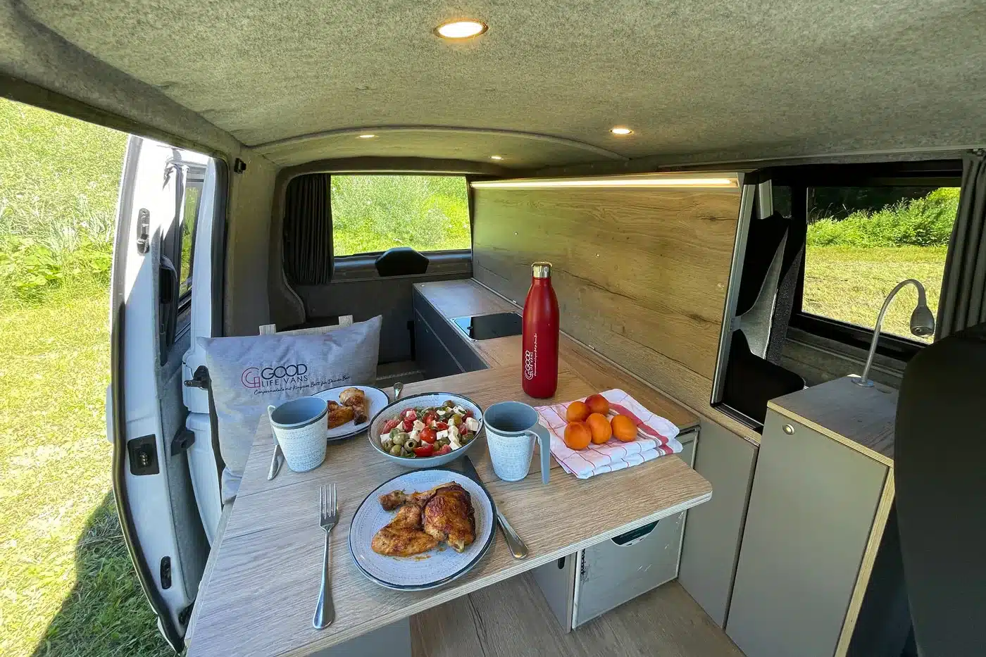 Innenraum eines VW T6 mit Camper Module ONE, Küchenzeile, Spüle und Esstisch von Good Life Vans