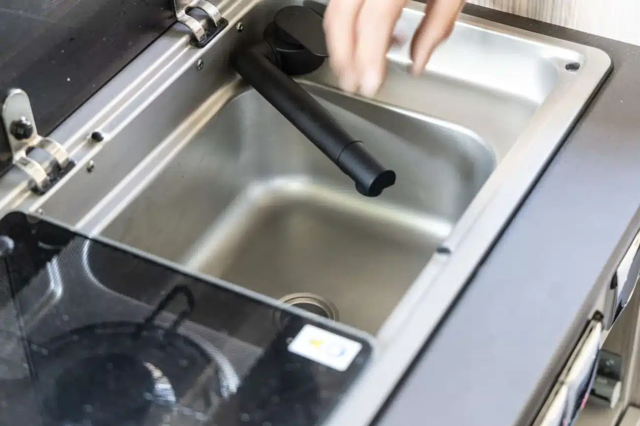 Schwarze Wasserhahn-Armatur über einer Edelstahlspüle im Camper