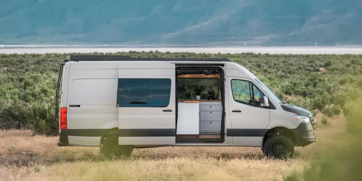 Weißer VanCraft Waypoint XL Campervan mit geöffneter Seitentür in einer kargen Landschaft