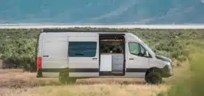 Weißer VanCraft Waypoint XL Campervan mit geöffneter Seitentür in einer kargen Landschaft