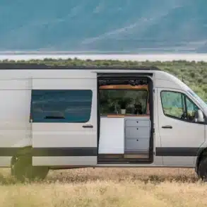 Weißer VanCraft Waypoint XL Campervan mit geöffneter Seitentür in einer kargen Landschaft