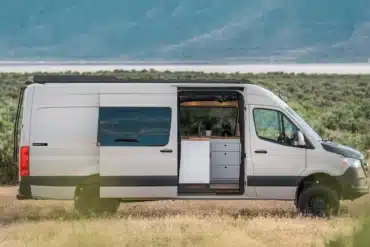 Weißer VanCraft Waypoint XL Campervan mit geöffneter Seitentür in einer kargen Landschaft