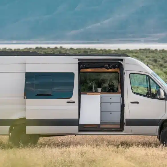 Weißer VanCraft Waypoint XL Campervan mit geöffneter Seitentür in einer kargen Landschaft