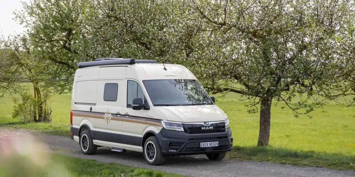 WESTFALIA Sven Hedin 50 Jahre Edition in heller Sonderlackierung auf einer Landstraße unter blühenden Bäumen