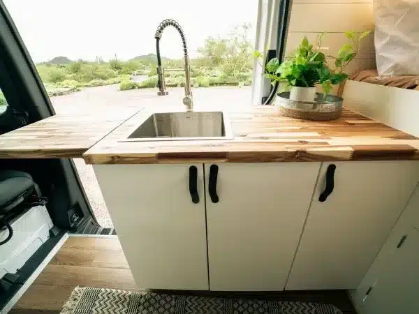 Küchenzeile im Campervan Papago Vans Zion mit Holzarbeitsplatte, Edelstahlspüle und Wasserhahn